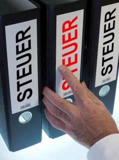 Hand reaching for file folders labeled 'Steuer'