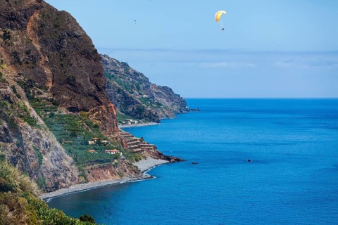 Cliff coast near Calheta with paragliders