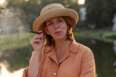 Woman smoking a cigar on a houseboat on the Canal des Vosges