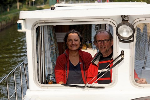 Woman and man at the wheel of a Penichette