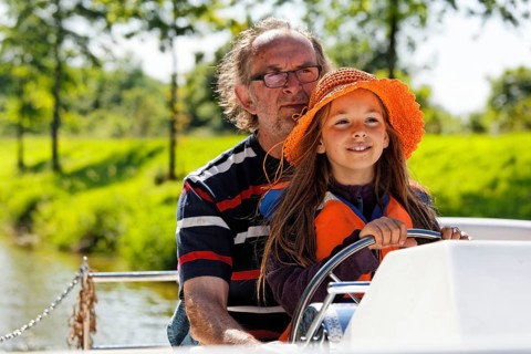 Father and daughter at the wheel of a Penichette