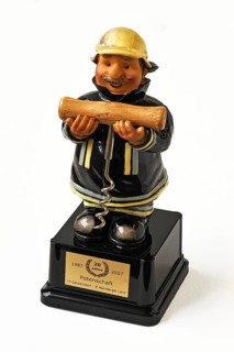Figure of a firefighter holding a corkscrew in his hands