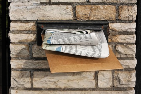 Full letter box of a house in a wall