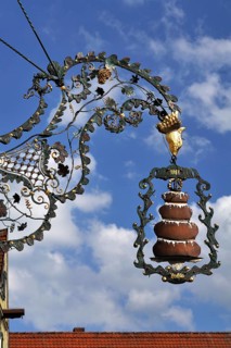 Hanging sign with a 'Baumkuchen' or tree cake from the Kaffeehaus Trexler coffee house