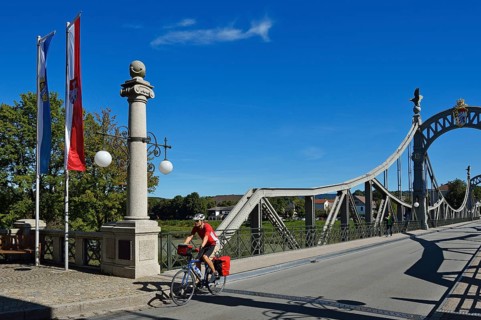 Cyclist crossing Laenderbruecke bridge between Bavaria and Salzburger Land