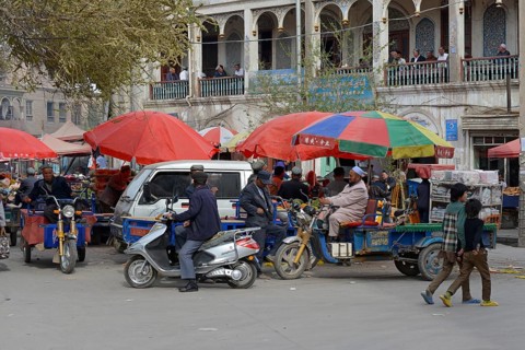 Market stalls with Muslim traders and a tea room on the porch of a mudbrick house