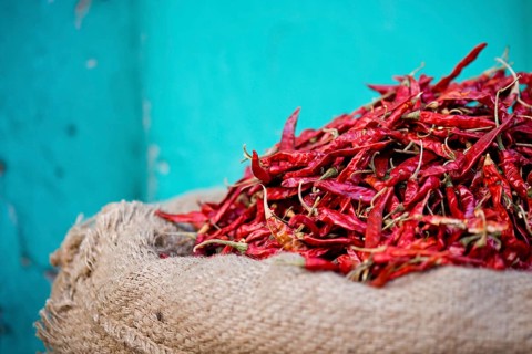 Red chillies in a sack against a turquoise wall