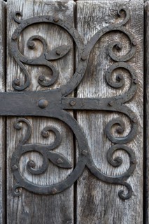 Hand-forged iron works on a wooden door