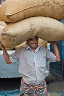 Man carrying two bags filled with spices on his head