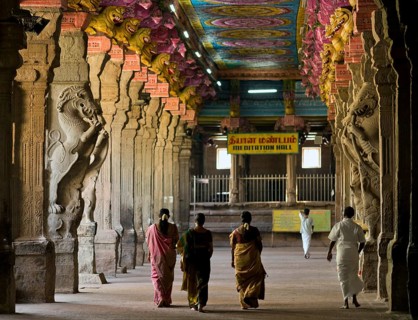 Visitors in the temple hall with brightly painted pillars