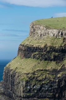 Man with a dog at the top of a cliff