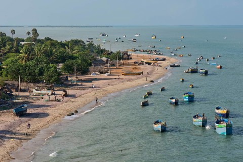 Fishing boats and fishermen's huts on the beach