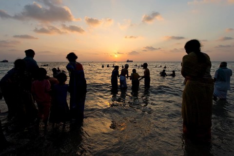 Hindu pilgrims taking a holy bath in the sea at sunrise
