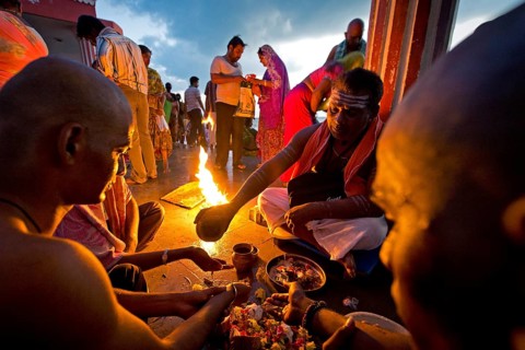 Hindu priest with pilgrims during a fire ritual at the Ghat Agni Theertham
