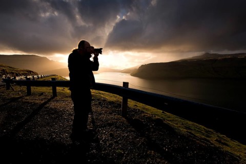 Silhouette of a photographer standing in front of dramatic