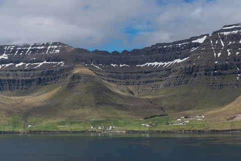 Kunoy village by the sea in front of steep mountains