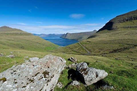 View over boulders and the village of Funningur towards Djupini Fjord