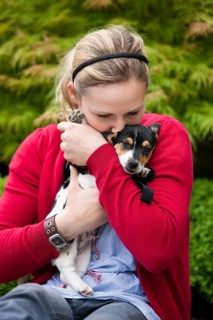 Young woman cuddling a Jack Russell puppy