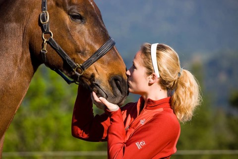Young woman cuddling an Austrian Warmblood