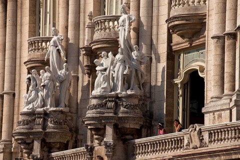 Statues and a balcony with visitors on the facade of the Gran Teatro de La Habana theater