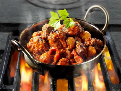 Indian Piri Piri chicken curry being cooked over hot charcoals