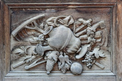 Carved relief image with agricultural motifs on the wooden portal