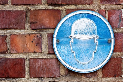 A faded sign at a construction site to wear a hard hat
