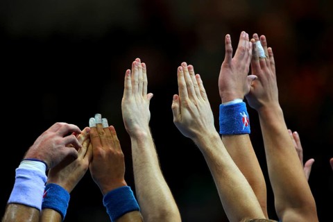 Handball players stretch their hands up to fend off a free-kick