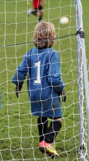 Youth team goalkeeper standing in goal