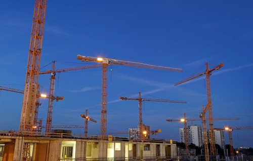 Construction cranes on the construction site of the Milaneo at dusk