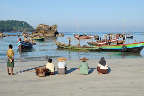 A fisherman's family is waiting on the beach for the return of the boats