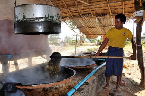 Man pouring sugar juice from one vessel to another
