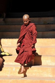 Young Buddhist monk stepping out of a monastery