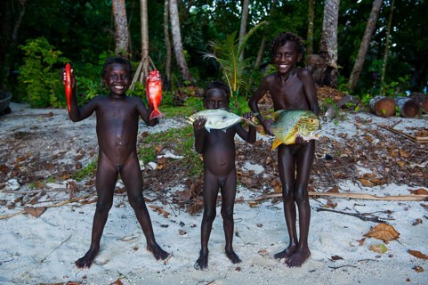 Boys proudly showing the fish they caught