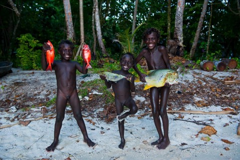 Boys proudly showing the fish they caught