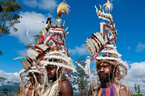 Members of a tribe in colourfully decorated costumes with face paint at the traditional sing-sing gathering