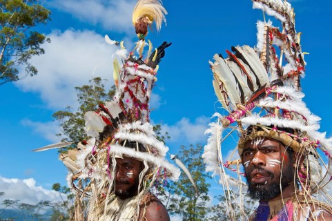 Members of a tribe in colourfully decorated costumes with face paint at the traditional sing-sing gathering