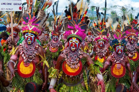 Members of a tribe in colourfully decorated costumes with face paint at the traditional sing-sing gathering