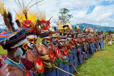 Members of a tribe in colourfully decorated costumes with face paint at the traditional sing-sing gathering