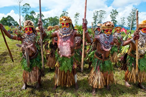 Members of a tribe in colourfully decorated costumes with face paint at the traditional sing-sing gathering