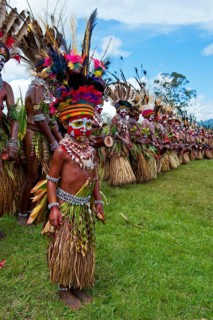 Members of a tribe in colourfully decorated costumes with face paint at the traditional sing-sing gathering
