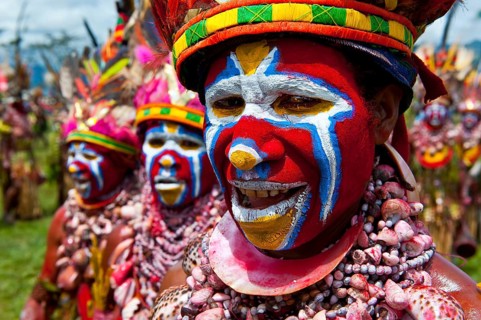 Members of a tribe in colourfully decorated costumes with face paint at the traditional sing-sing gathering