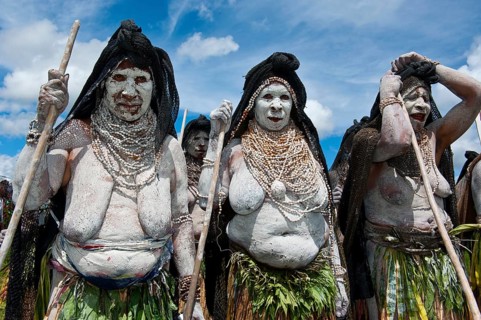 Women in colourfully decorated costumes with face and body paint at the traditional sing-sing gathering