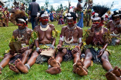 Women in colourfully decorated costumes with face paint at the traditional sing-sing gathering