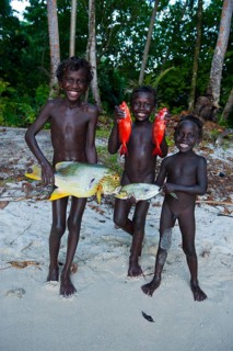 Boys proudly showing the fish they caught