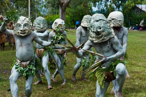 Tribal members in masks and full body paint are celebrating at the traditional Sing Sing gathering in the highlands