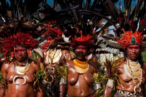 Women in colourfully decorated costumes with face paint at the traditional sing-sing gathering