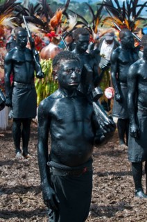 Members of a tribe covered in black paint at the traditional sing-sing gathering