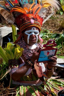 Woman applying make-up or face paint at the traditional sing-sing gathering