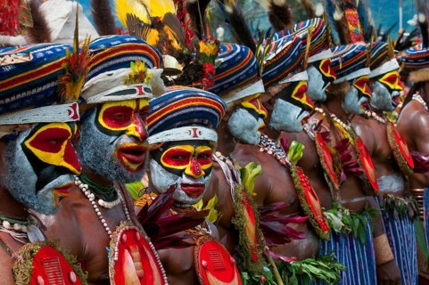 Members of a tribe in colourfully decorated costumes with face paint at the traditional sing-sing gathering